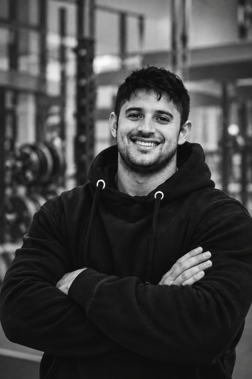 Kevin Medrano, founder and head coach of AKM Training, standing arms crossed in the gym